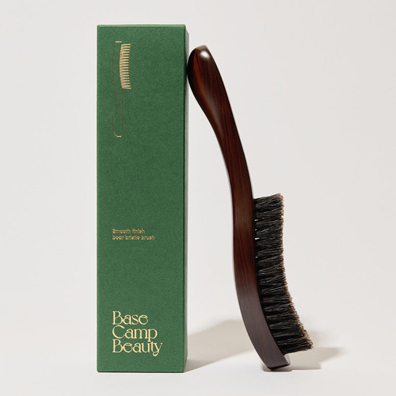 styled photography wooden smoothing brush leaning on green box