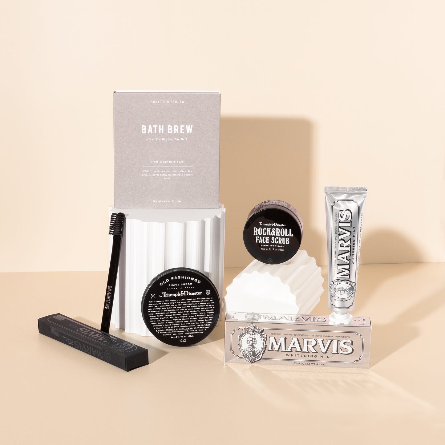 Style Photography of pamper gifts for him filled with men's self care products such as shaving cream , face scrub , toothpaste and bath soak