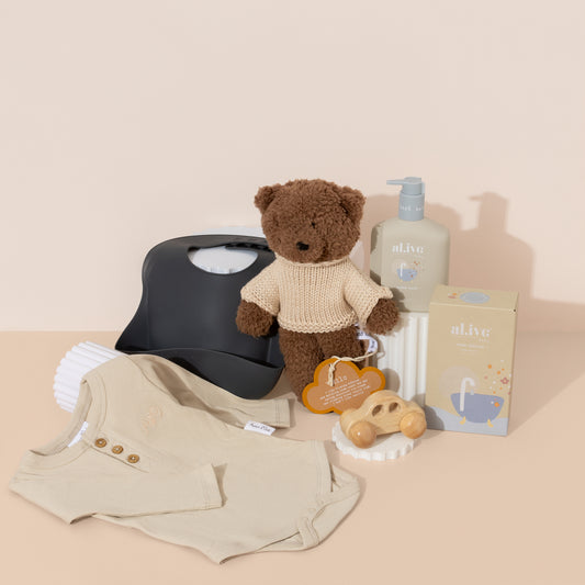 Baby Boy gift hamper filled with newborn essentials such as silicone bib, onesie, teddy bear , wooden car toy and baby bubble wash