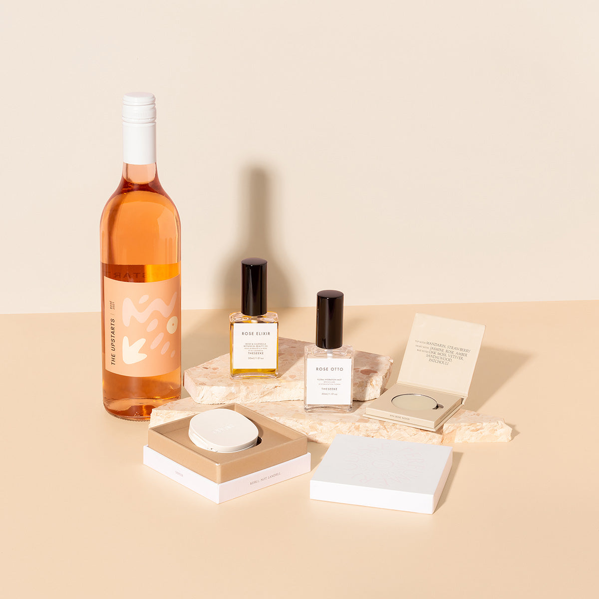 beauty gift hamper filled with Rose bottle of wine, beauty oil and mist , solid perfume with matching sustainable compact vessel 